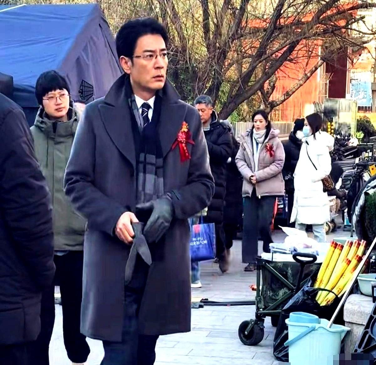 同一朵红花，戴在两个人身上，简直是两个世界。李光洁西装笔挺，金丝眼镜，手插兜