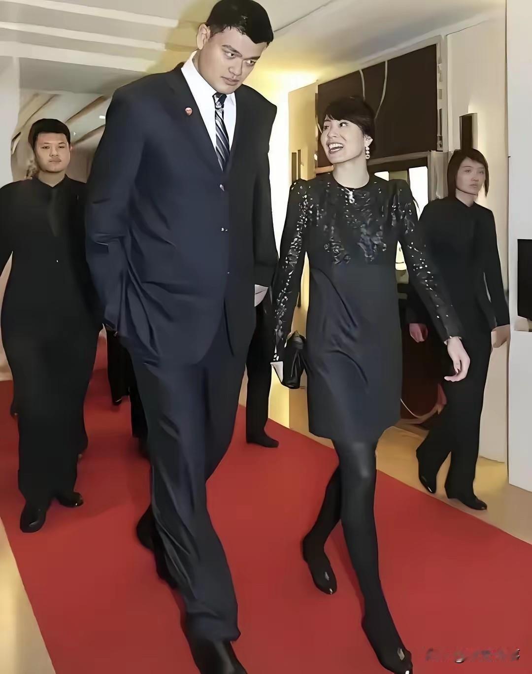 姚明与妻子叶莉同框，篮坛巨人夫妻，双向奔赴的爱情佳话。镜头下，姚明身着深色西装，