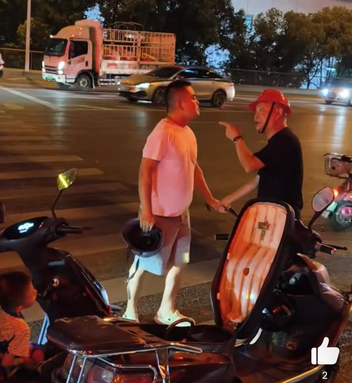 长沙街头两电瓶车司机发生摩擦，一方拿着头盔，一方拿着铁锤，现场火星四溅，幸好一路