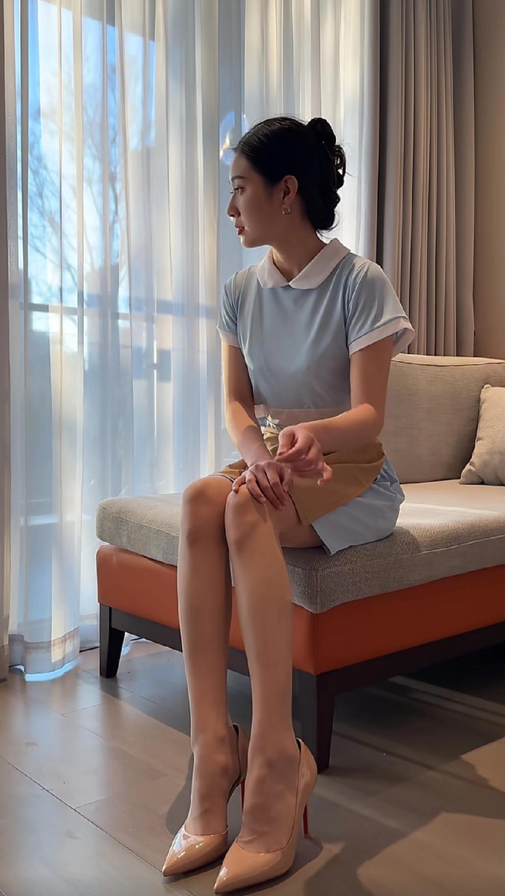 优雅蓝裙搭配高跟鞋，静坐窗边，享受宁静时光。