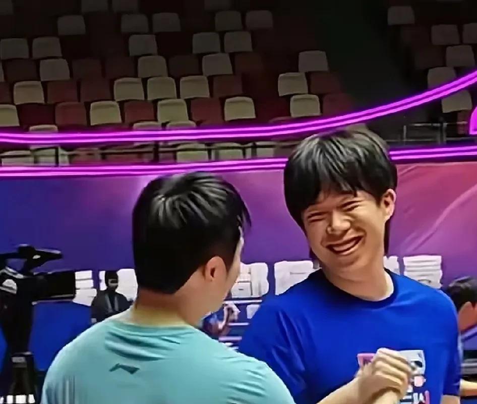东楚霸王在训练场击掌握手。两个人都笑容满面。不过王楚钦的头发为啥不剪剪，大夏天的