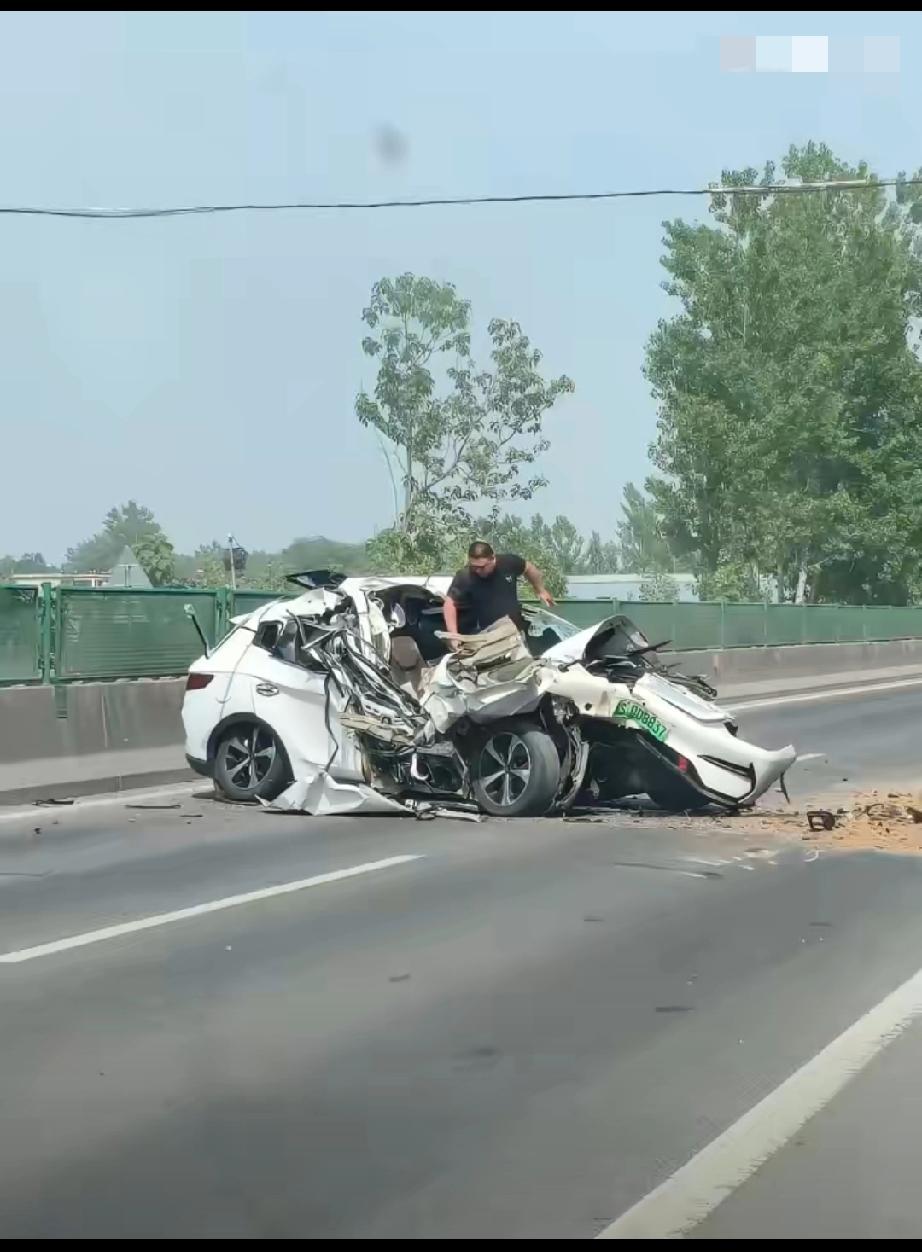 比亚迪宋又出神图，百公里车速撞渣土车，车碎了但车主没事，从车里爬出，看图右侧脸有