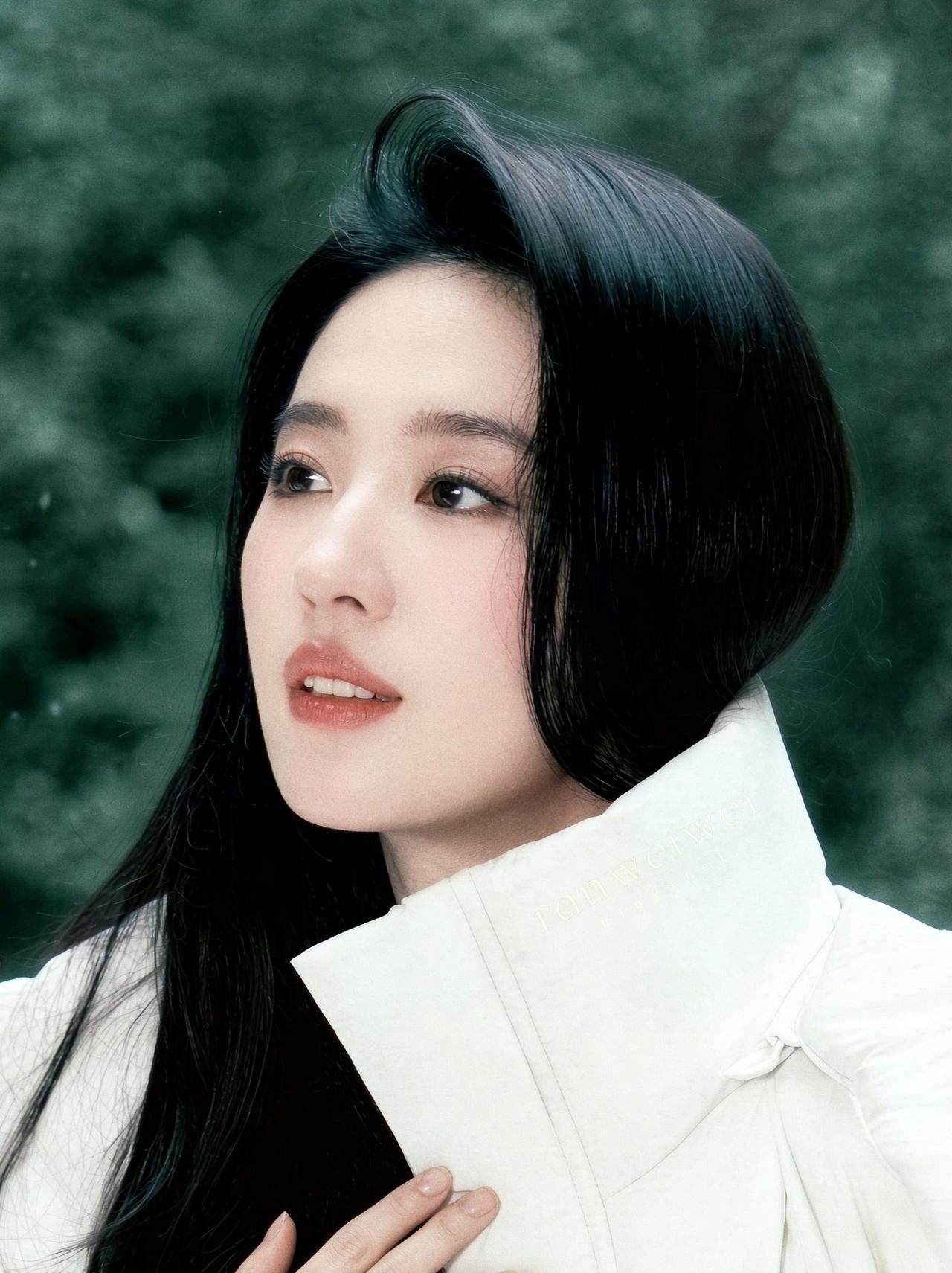 白雪林间，一袭长款米白羽绒服，刘亦菲从容而立。没有繁复的修饰，简约的冬日穿搭，衬