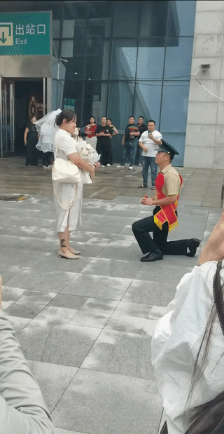 刚刚退伍回家的男子突然在火车站门口向他的女朋友单膝跪地，求婚表白？他希望女友能