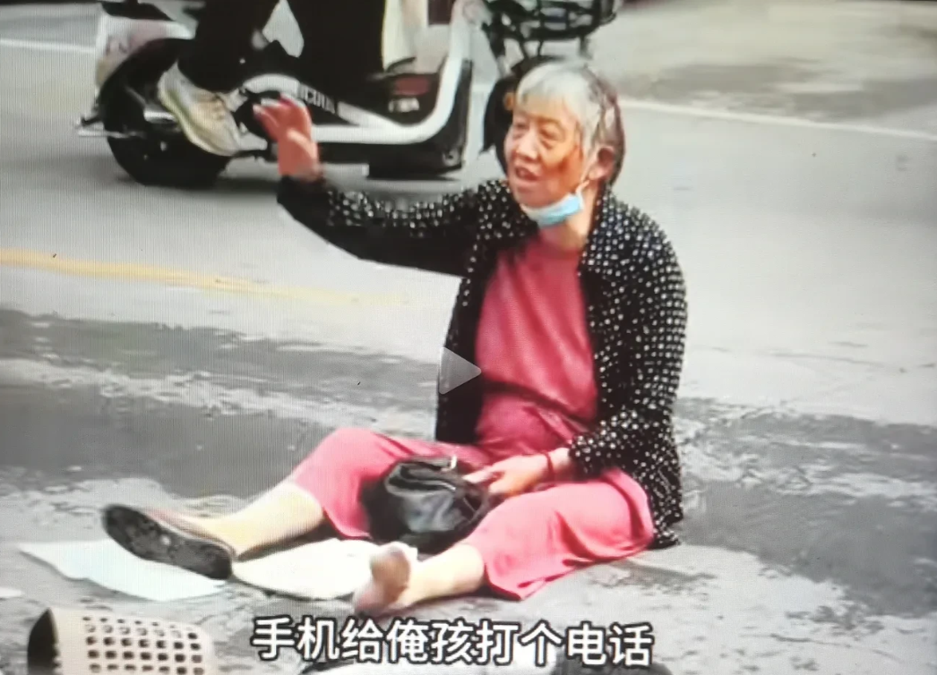 一老太太坐路中间，疑发生碰撞事故！欲借用路边女孩打电话给家人，被多个围观者大声制