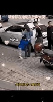 泪目了蓝衣服小男孩跑到女子跟前亲昵的抱住她，并喊着妈妈，后两人四目相对，男孩转