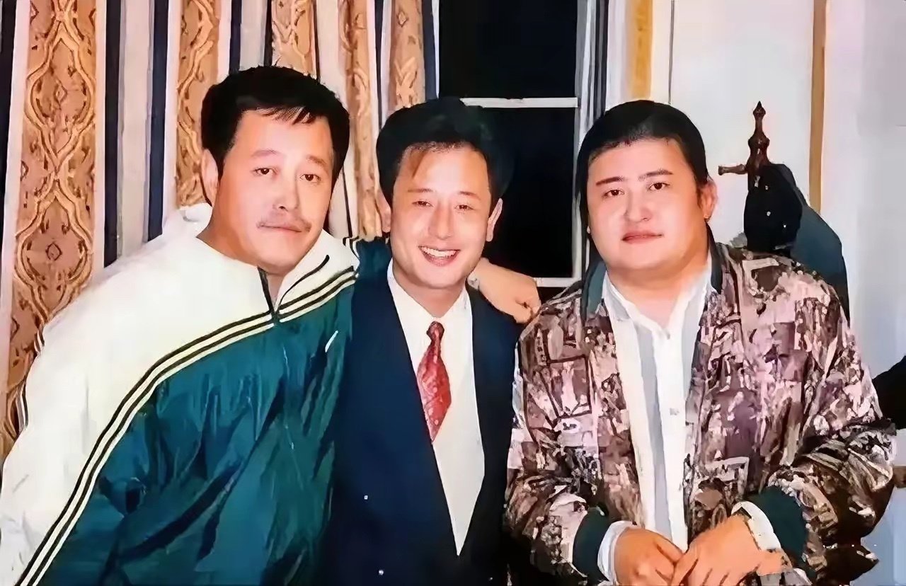 90年代早期的一张合影，左边穿着运动服留着小胡子的是赵本山，右边穿着时装留着大辫子的是刘欢，中间穿着