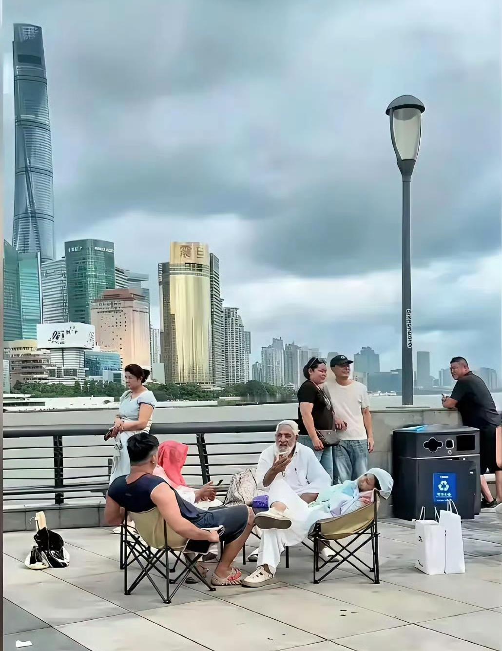 印三的高种姓家庭来上海旅游！他们将折叠桌椅带到了外滩，一家子旁若无人随意坐卧，