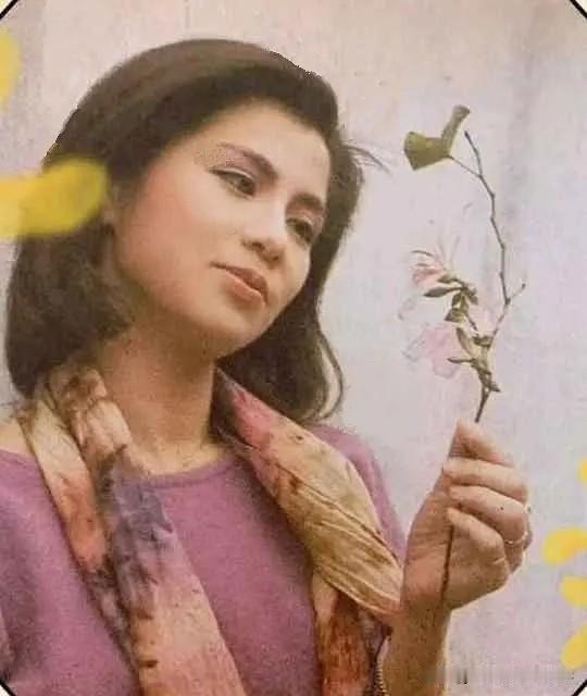 翁美玲美照📸手持花枝,紫衫围巾,眉眼间是独属于那个年代的优雅与风情,一帧定格