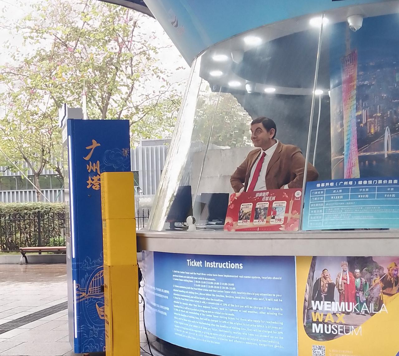 看看广州塔下憨豆先生的表情很搞怪啊！周边的绿化树叶很嫩，很绿，很清新！