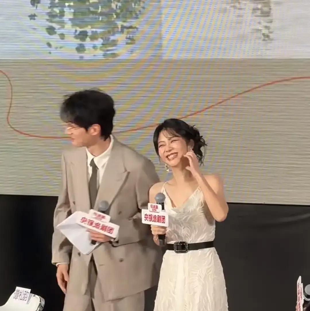 大热天的活动现场，刘学义手里捏着张薄纸拼命给自己扇风，汗顺着脸直往下淌，还得强撑着陪旁边的谭松韵玩互