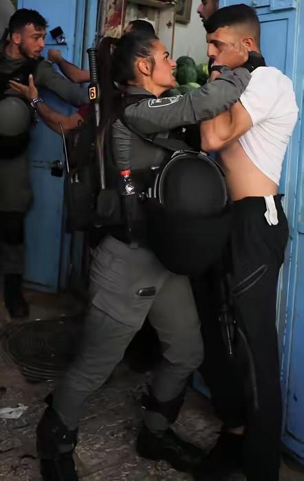 以色列女兵一把按住一名巴勒斯坦男人，真要打，这名强壮的巴勒斯坦男人可以直接干翻这