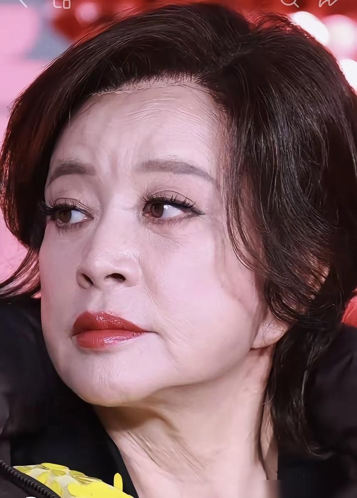 75岁的刘晓庆在桃花树下踮起脚尖，跟小她30岁的男演员金珈来了个肉搏式深吻。镜头