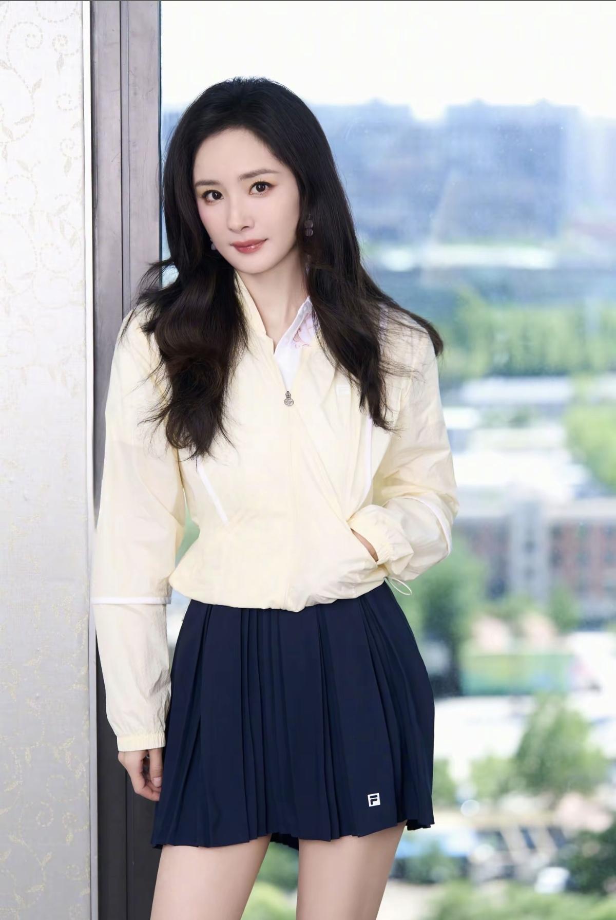 FILA代言人杨幂上线！奶油黄外套配藏蓝百褶裙，把运动风穿出清甜少女感，这波春日