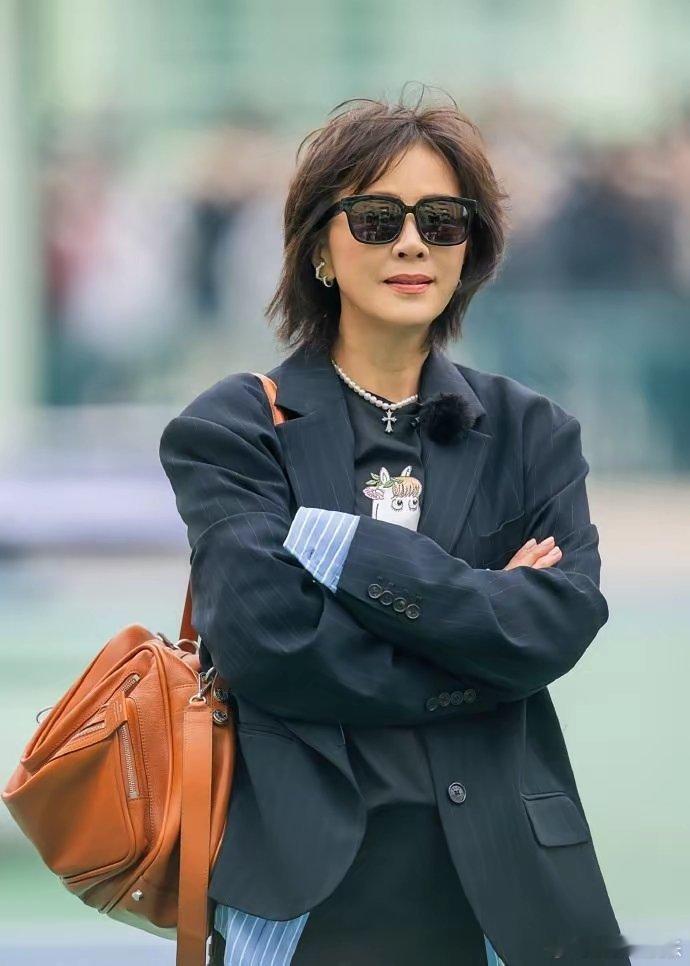 刘嘉玲54岁，上综艺穿得比年轻人还野。蓝衬衫套卡通T恤，裤子一蹬，尖头靴一踩，墨