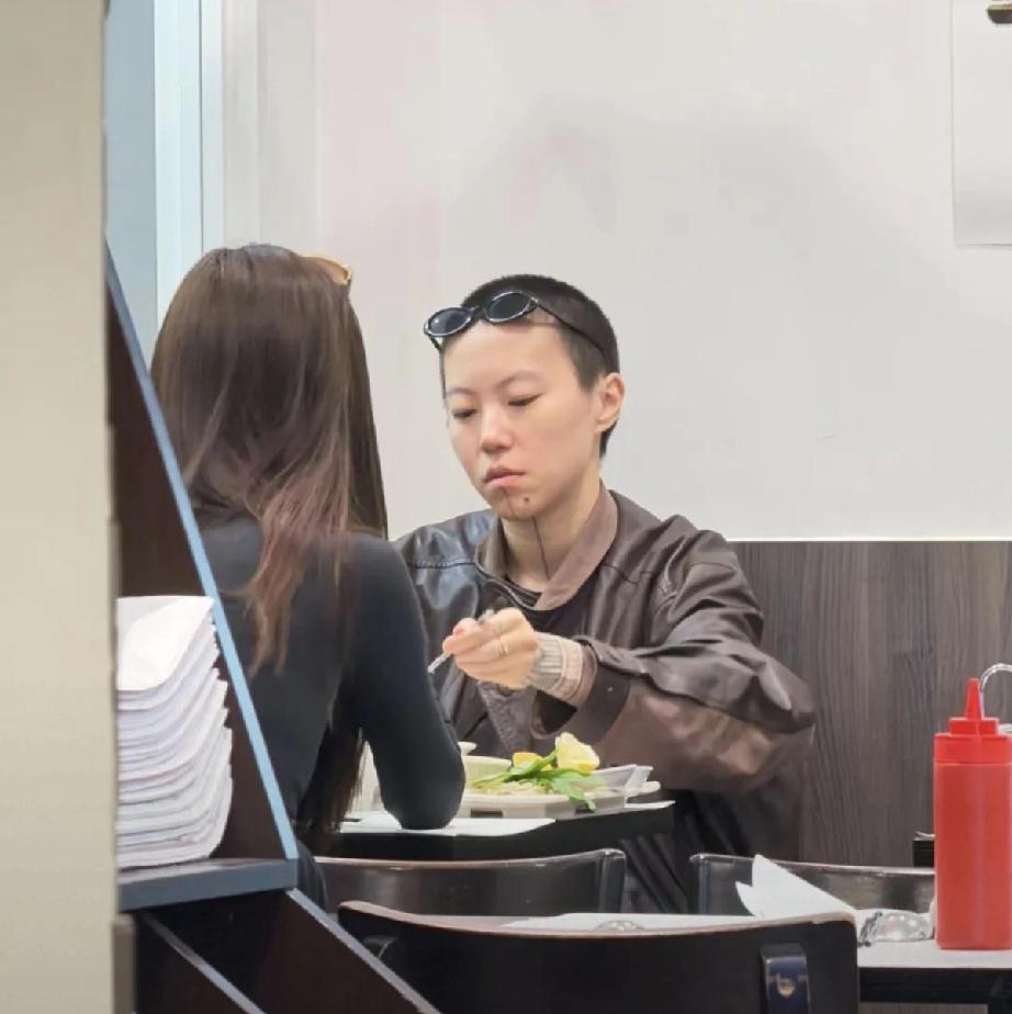 窦靖童留着板寸头，墨镜挂在脑门上，脖子纹着一条线，打扮中性，状态松弛到有点桀骜不