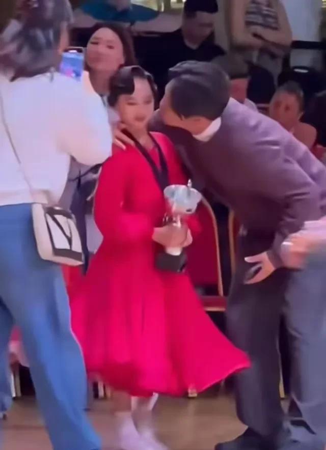 孙俪女儿在英国举行拉丁舞比赛夺得了冠军，她的指导老师高兴的情不自禁在孙俪女儿脸上