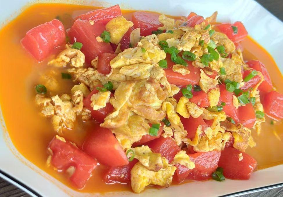 四个鸡蛋，炒熟后盛出备用​；西瓜红瓤切块备用；炒锅放油，加热后，倒入切块的西