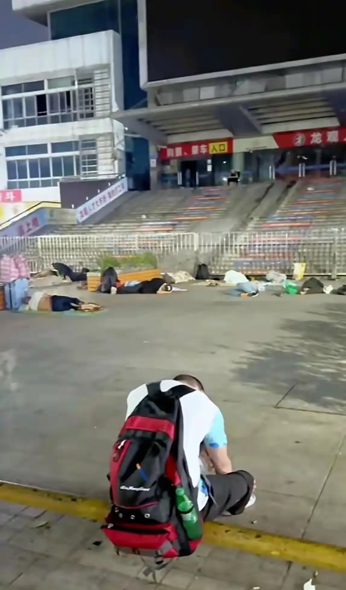 入夜的深圳龙华汽车站，门口睡着无数找不到工作的大哥。