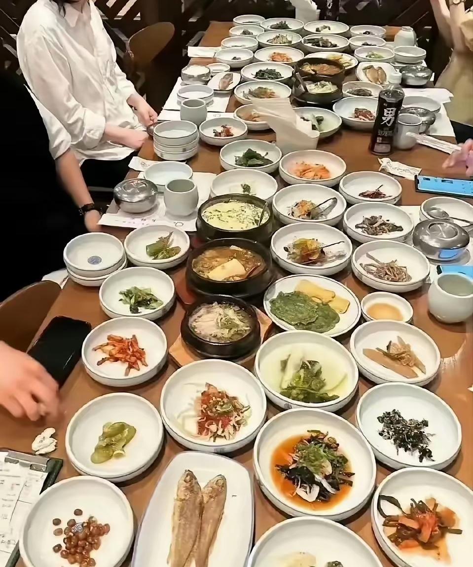 韩国4个人吃饭，桌上摆了超过50个盘子，让中国的九大碗相形见绌。韩国朋友问我，