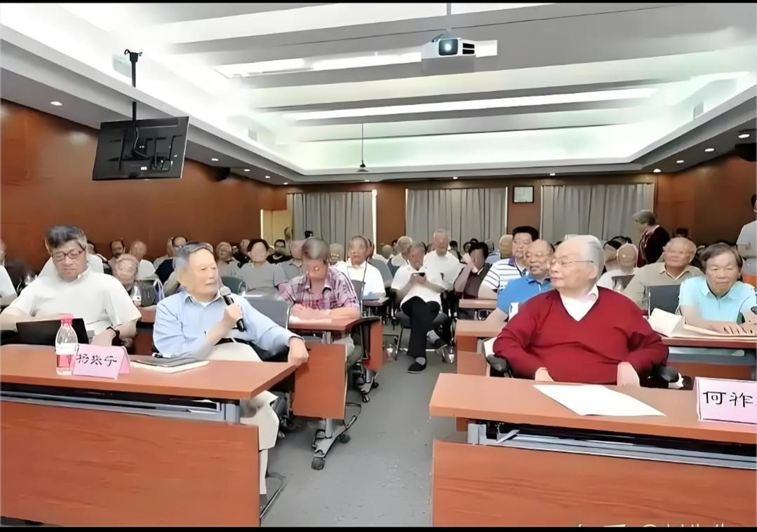 这是何祚庥院士与杨振宁先生的合影。这是当年学术交流的盛会，杨先生手拿话筒在阐述