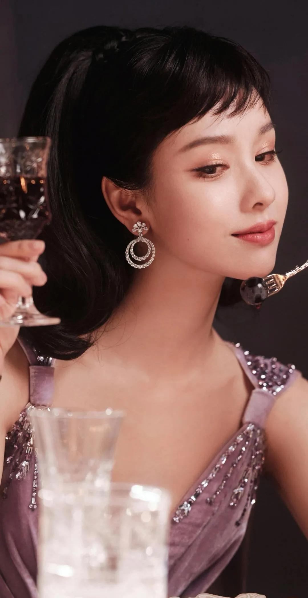 烛影摇红，陈都灵身着紫裙，似从旧时光走来。垂坠的亮片如星芒，勾勒出优雅肩线。她手