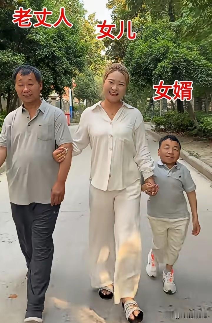 这到底是因为爱情还是因为金钱，个子那么的矮，这个美女感觉自己捡了一个宝似的，还牵
