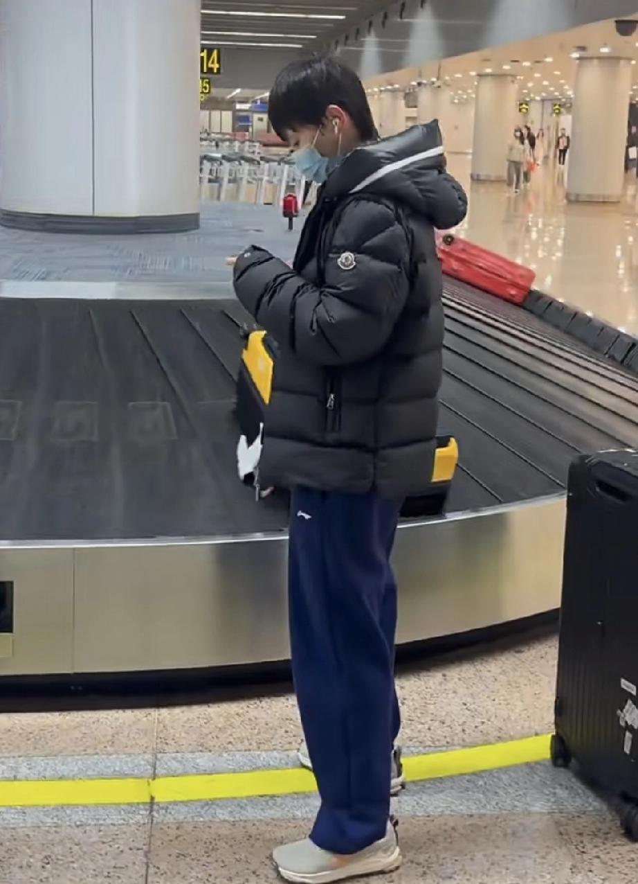 从海口回到北京首都机场，在行李提取处拿行李的王曼昱。还会先帮妹妹把行李一起搬下来