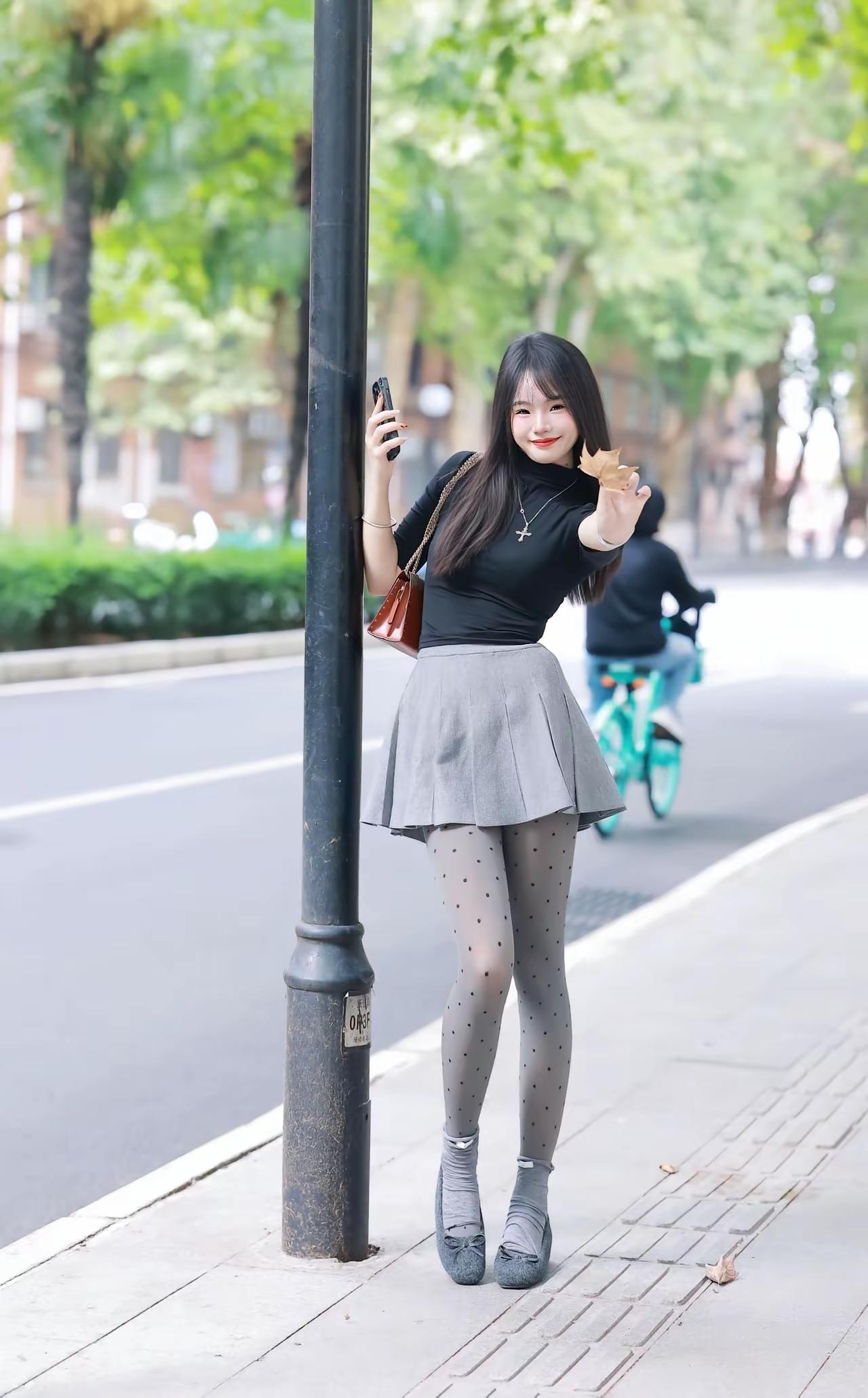 这姑娘在街边自拍呢。