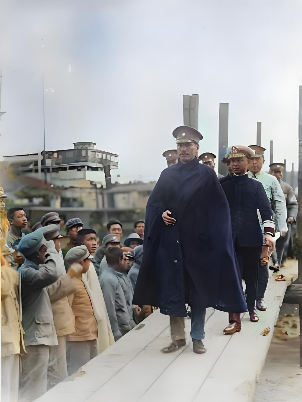 这是1931年蒋介石在汉口的影像。画面中他身着长款披风、头戴军帽，在随从陪同下