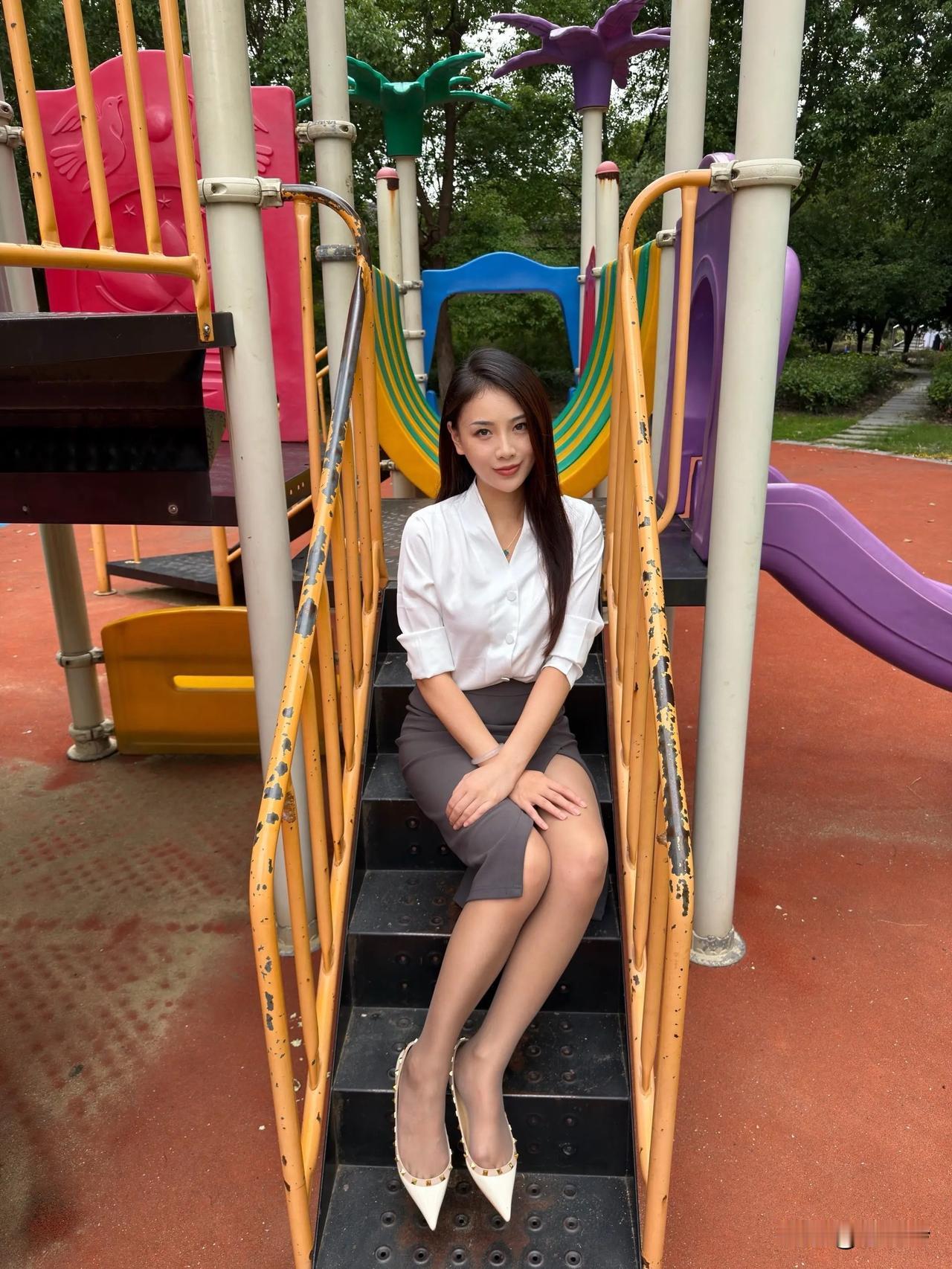 穿白衬衫的女士在游乐场摆姿势。