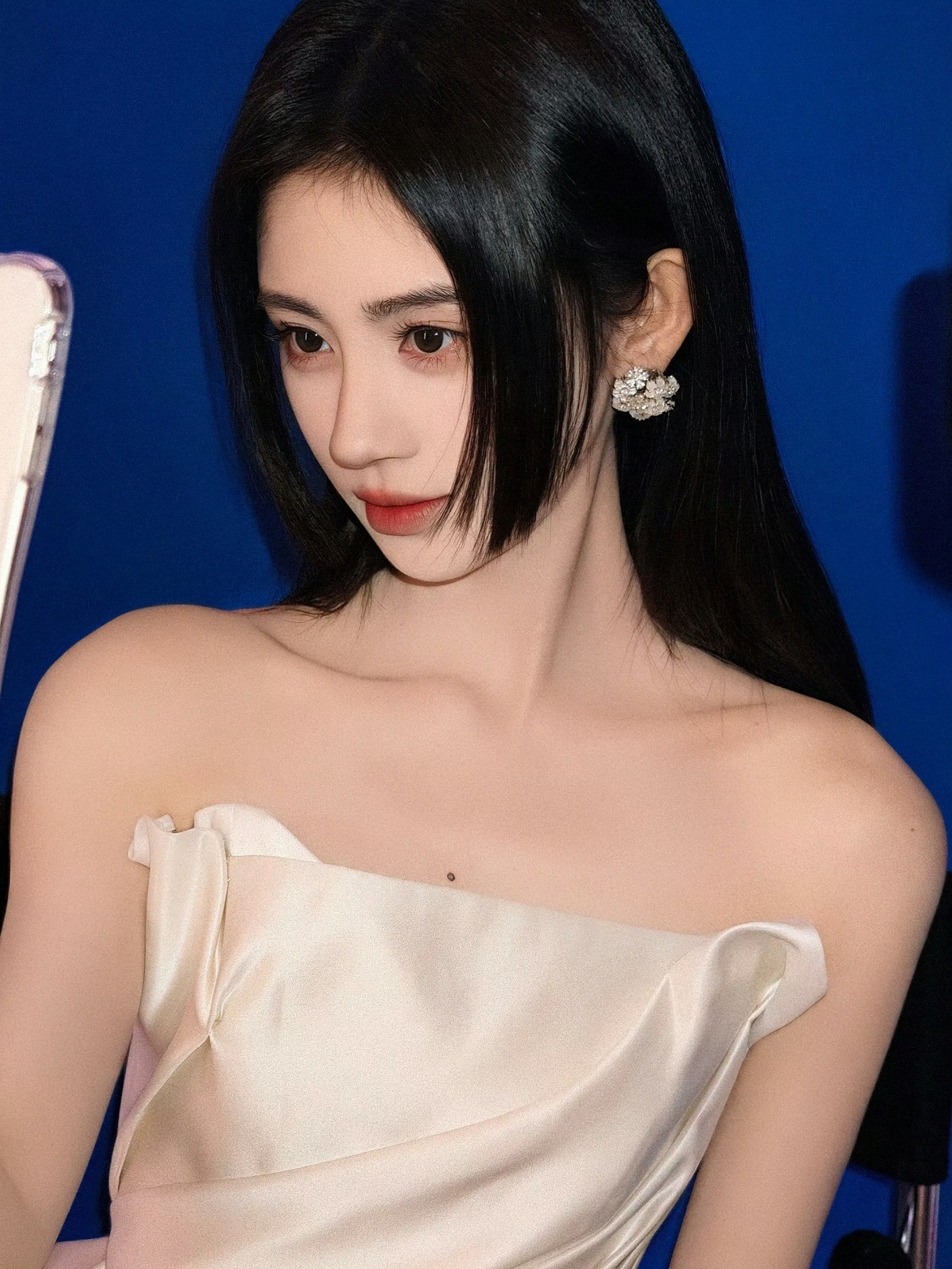 鞠婧祎公主切利落公主切搭配纯白抹胸礼裙，置身温柔粉调光影之中，发丝灵动飘逸柔美与
