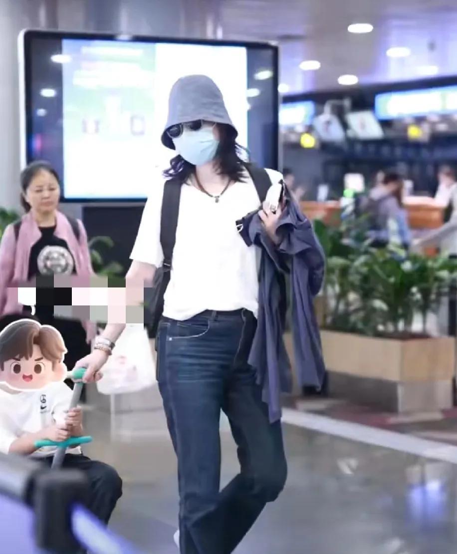 白百何带着二胎儿子现身机场时，有粉丝拍摄，儿子一直扭来扭去的对白百何说：“你挡我