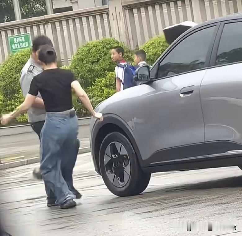 放学高峰校门口堵成一锅粥，这女的倒好，车往路边一横就不管了。保安大叔好心好意上去