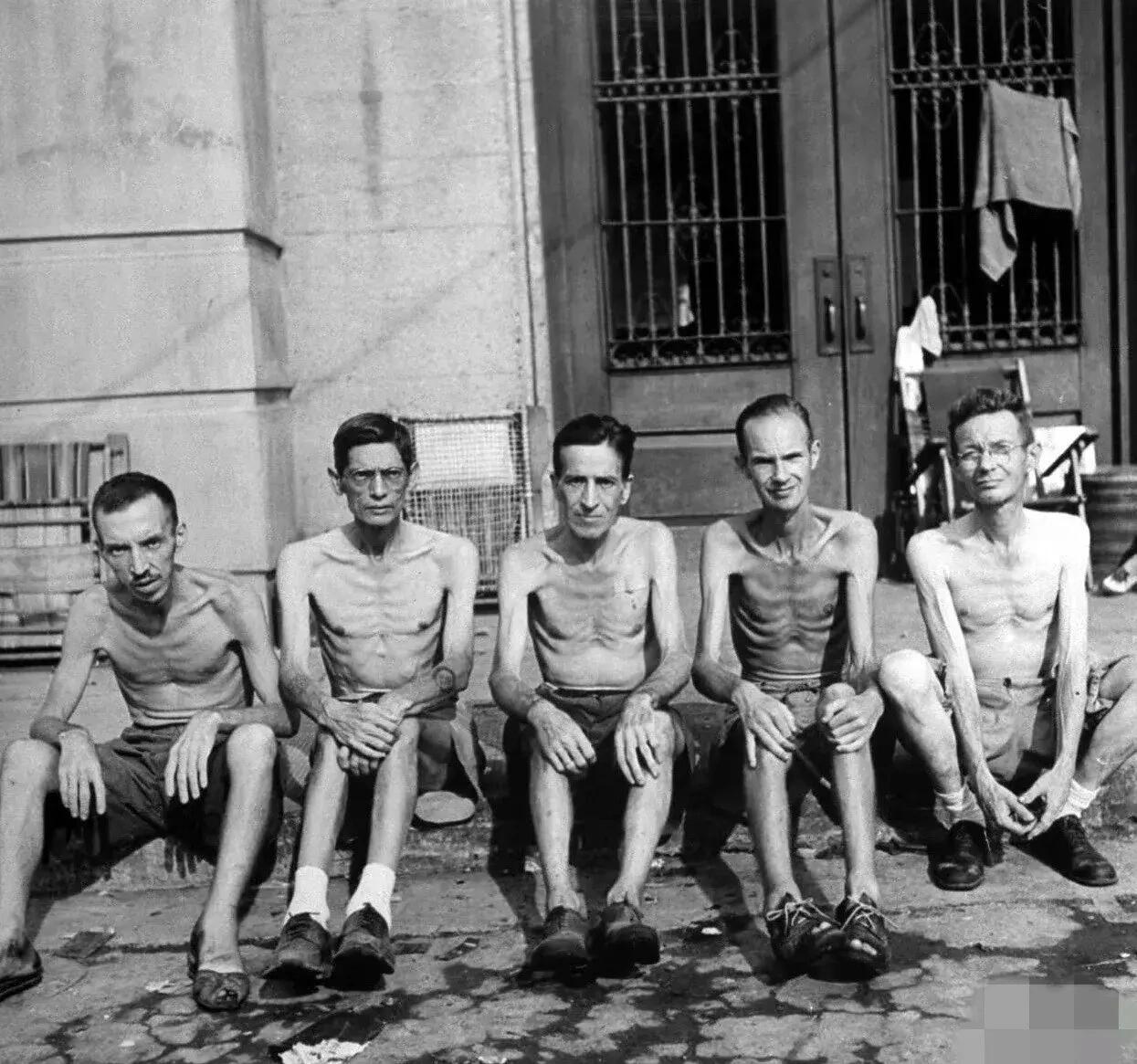 这张照片拍摄于1945年，五名被解救的美军士兵坐在路边，就在几个小时前，他们从菲