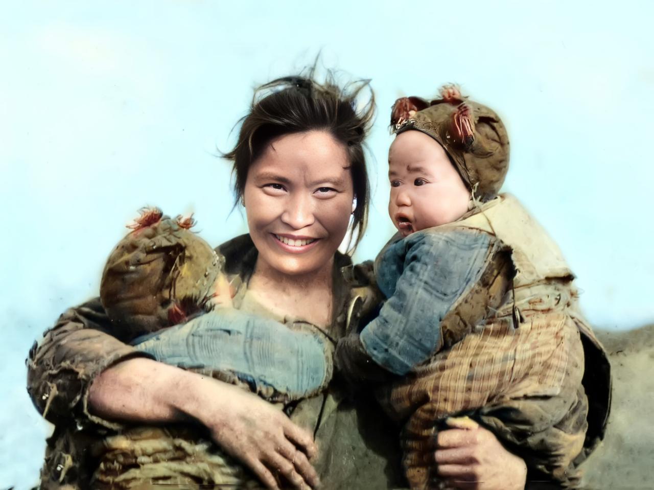 1930年的湖南衡阳。一位蓬头垢面、衣衫褴褛的年轻母亲抱着她的双胞胎儿子。两个孩