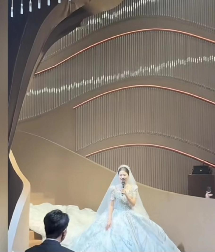 王正正身着婚纱，从旋转楼梯上一边唱着《爱就一个字》一边缓缓走下。那一刻，她宛如一