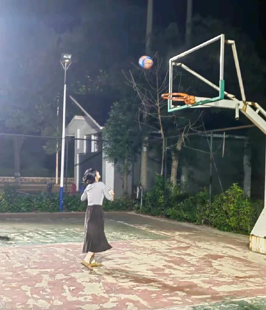 立秋后晚上凉快，跟媳妇出来散步，走进小区篮球场，她顺手拿着旁边的篮球玩了起来。