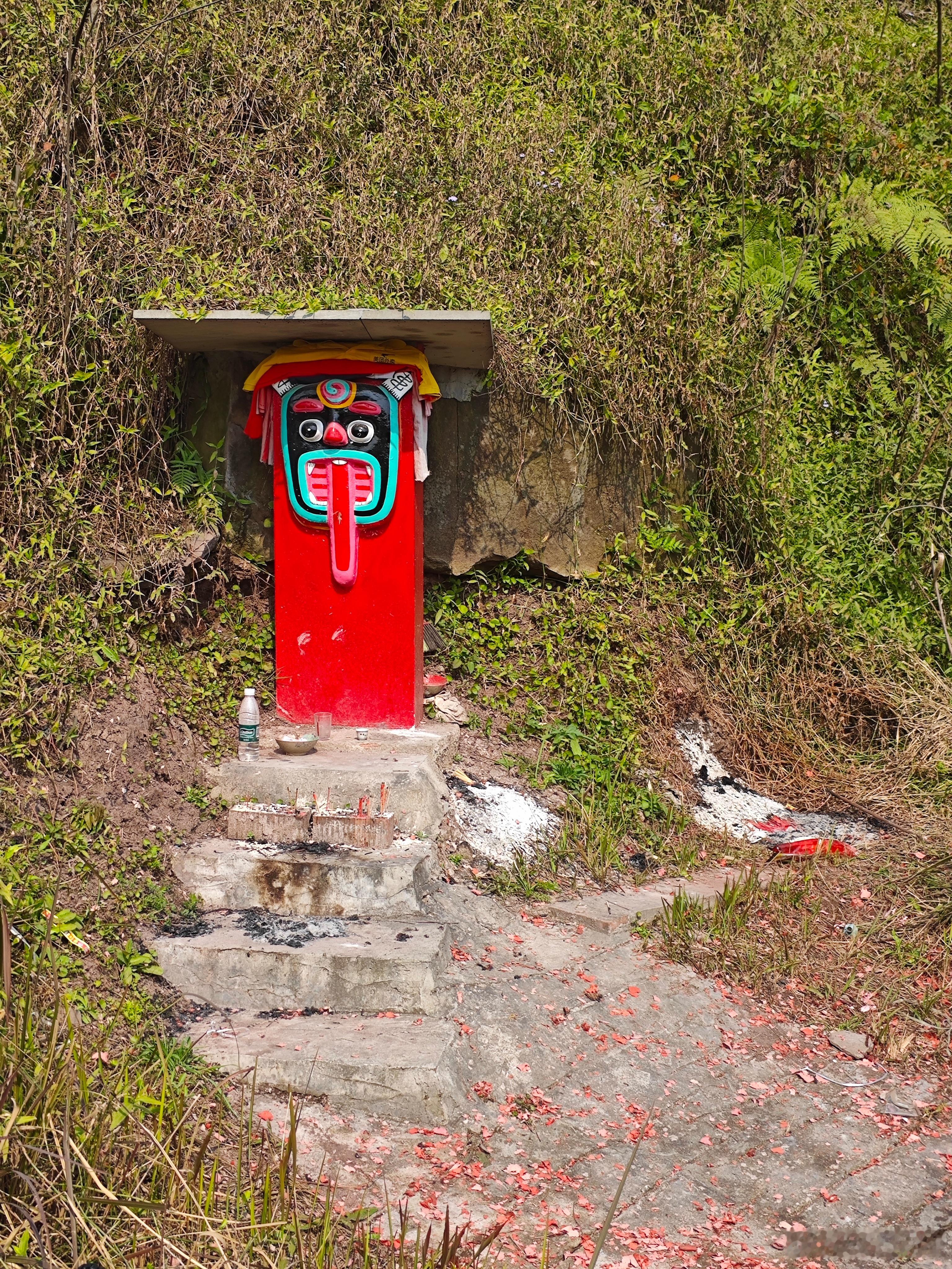 前几天在四川泸州附近走了一段国道，路边偶遇了民间小神龛供奉的红色立柱正面绘有吞口