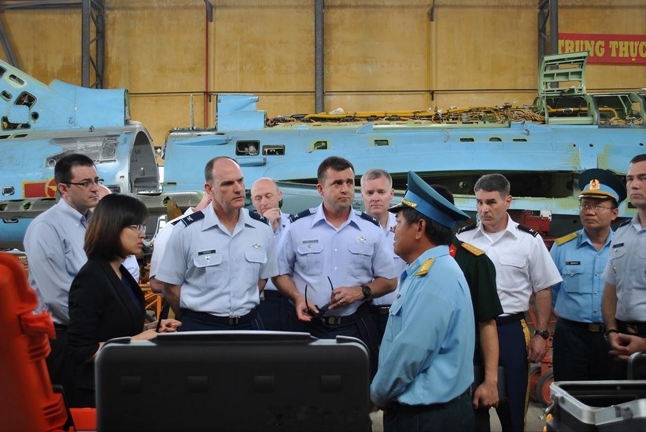 越南防空空军A32工厂的员工正在带领美国空军学院的代表团参观工厂。背景中是一架苏