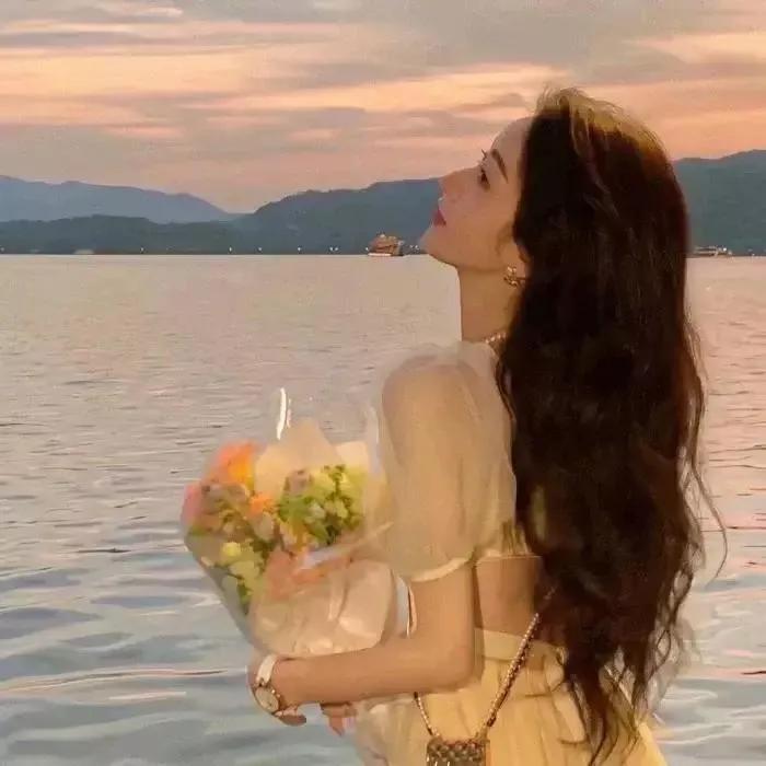 在湖边享受浪漫日落，手捧鲜花，感受生活的美好。湖畔风景照日落湖边景色湖边夕阳