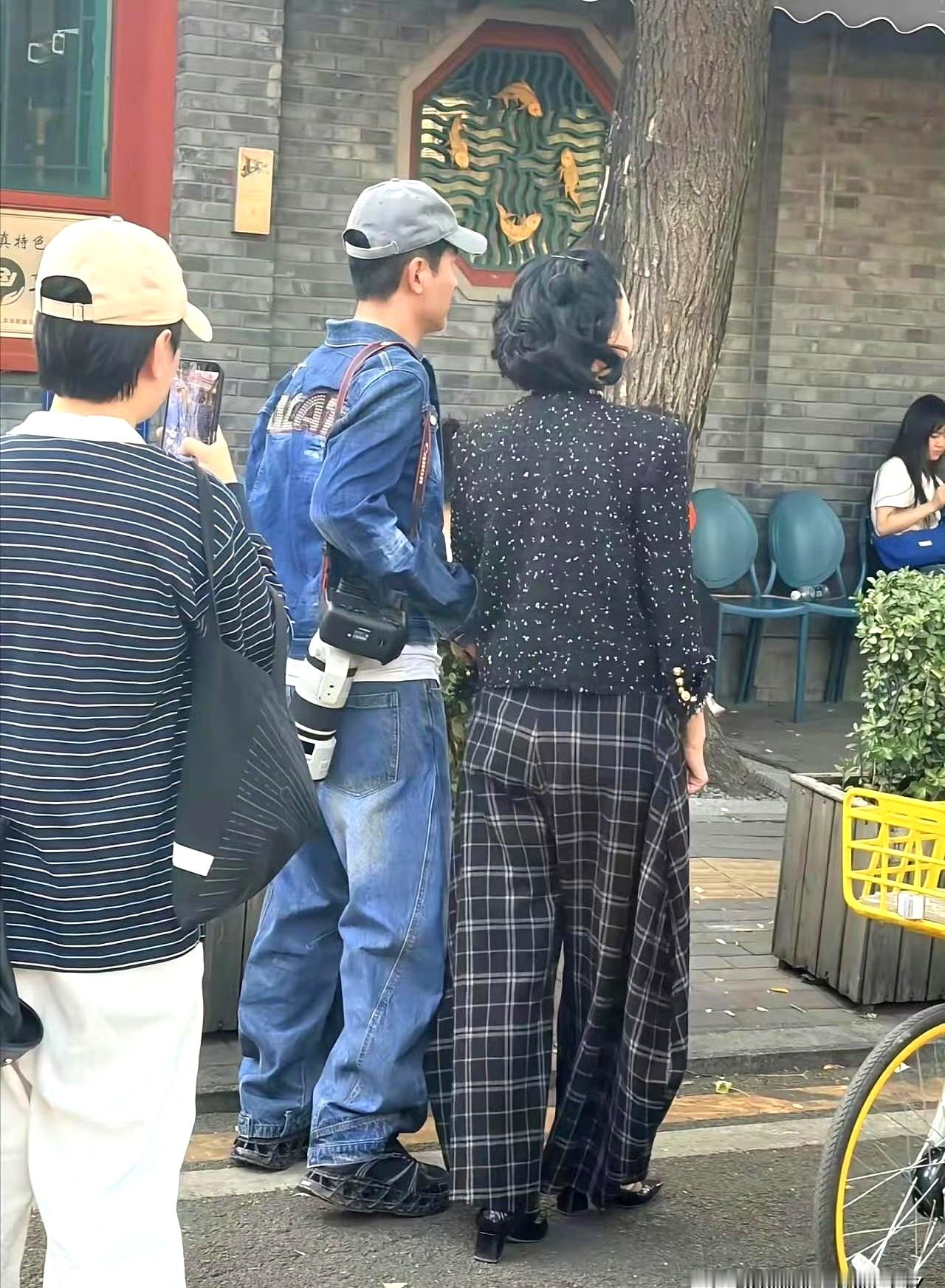 真没想到51岁的郭晓东出门这么随意，在北京公园散步时一点架子都没有背上挂着长筒摄像机，走到健身器材那