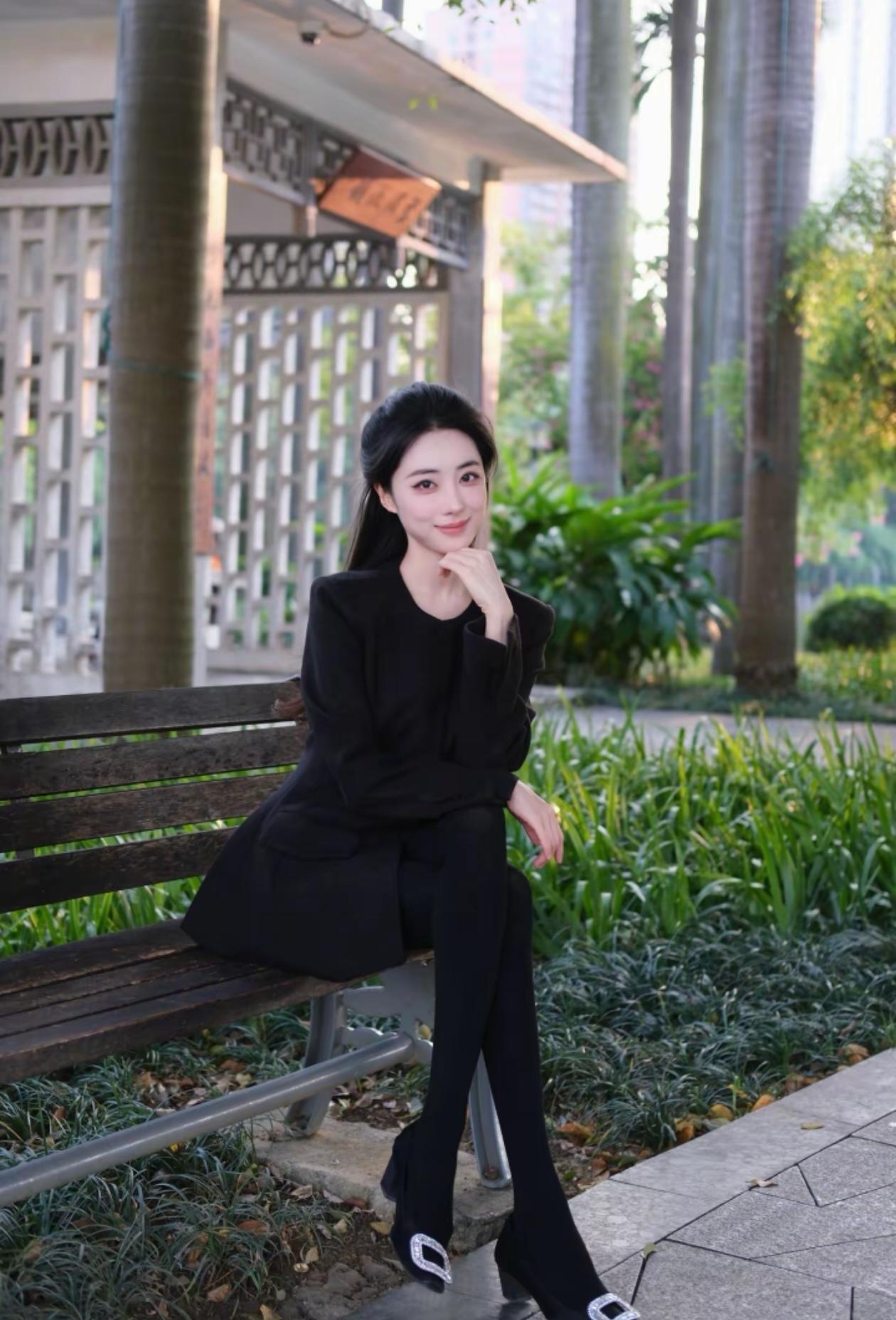 优雅黑衣，静坐长椅，享受宁静时光。