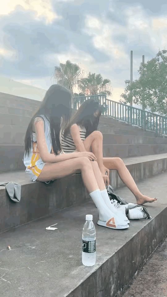 两个美女见有人拍她们娇嗔着用袜子扔过来。路过操场见到两个长腿小姐姐换袜子，本来想