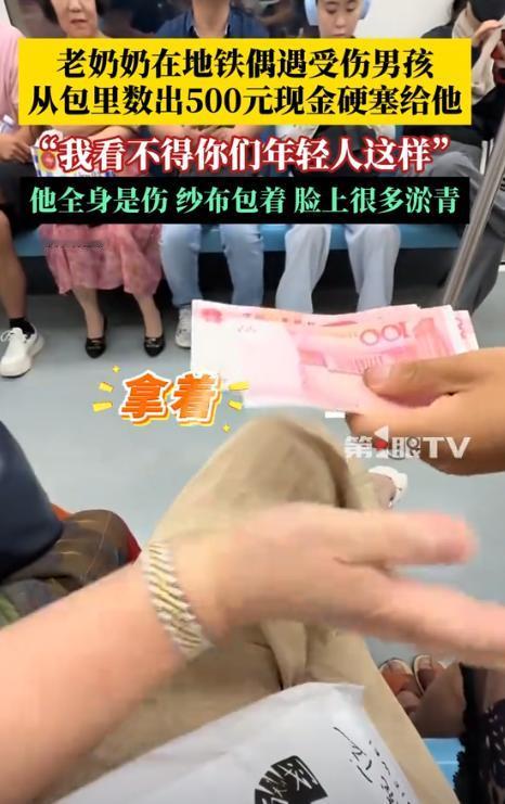 近日，上海，地铁上，一位男孩拿着500块现金，递给旁边的陌生奶奶，奶奶连忙摆手拒