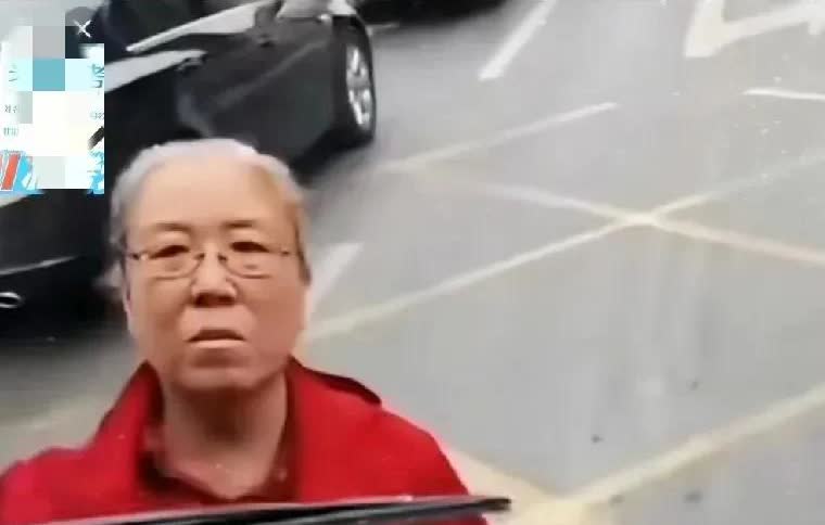 看看这位红衣老太太，公交车已经驶离站点，她却站在车前拦着不让走，非要逼着司机给她