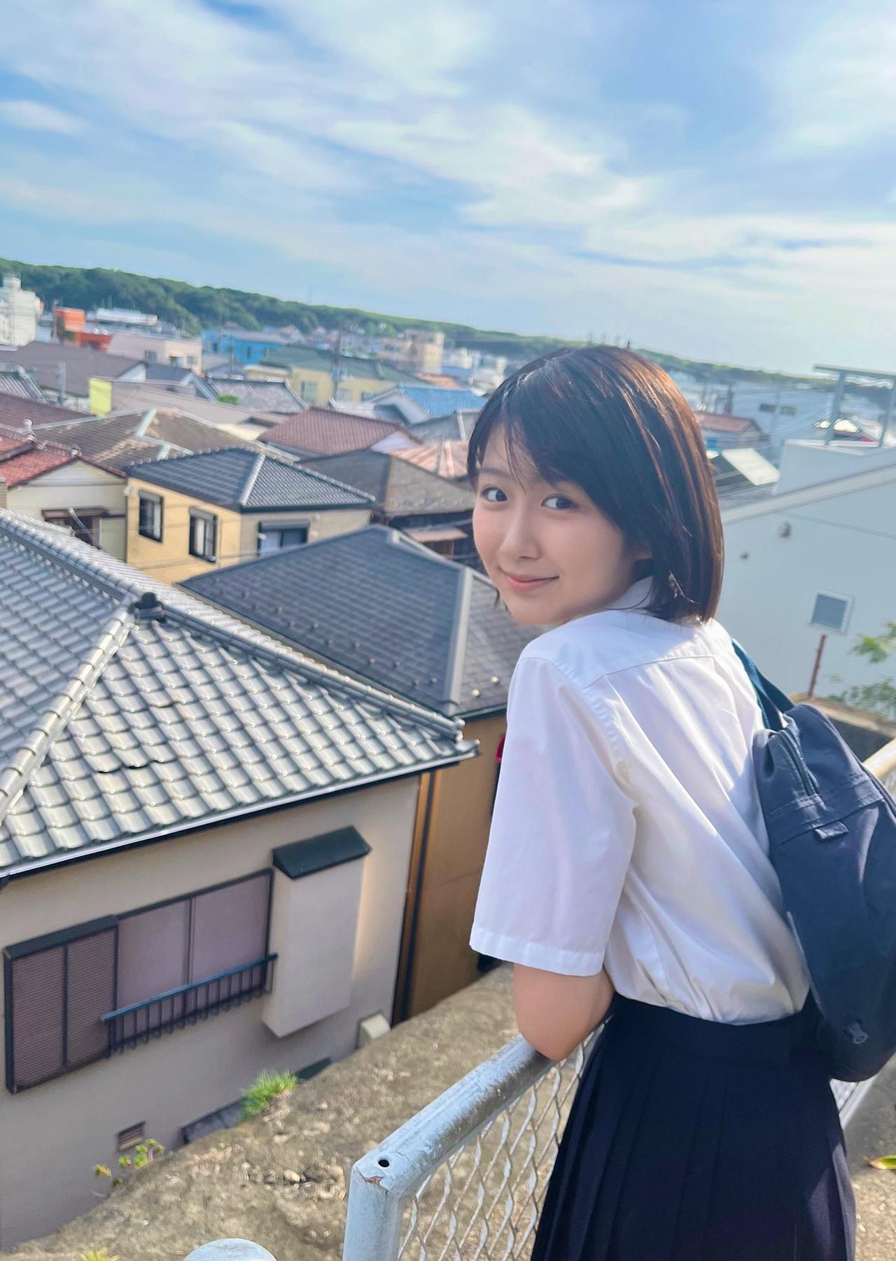 阳光下的校园少女，微笑着眺望城市风景。