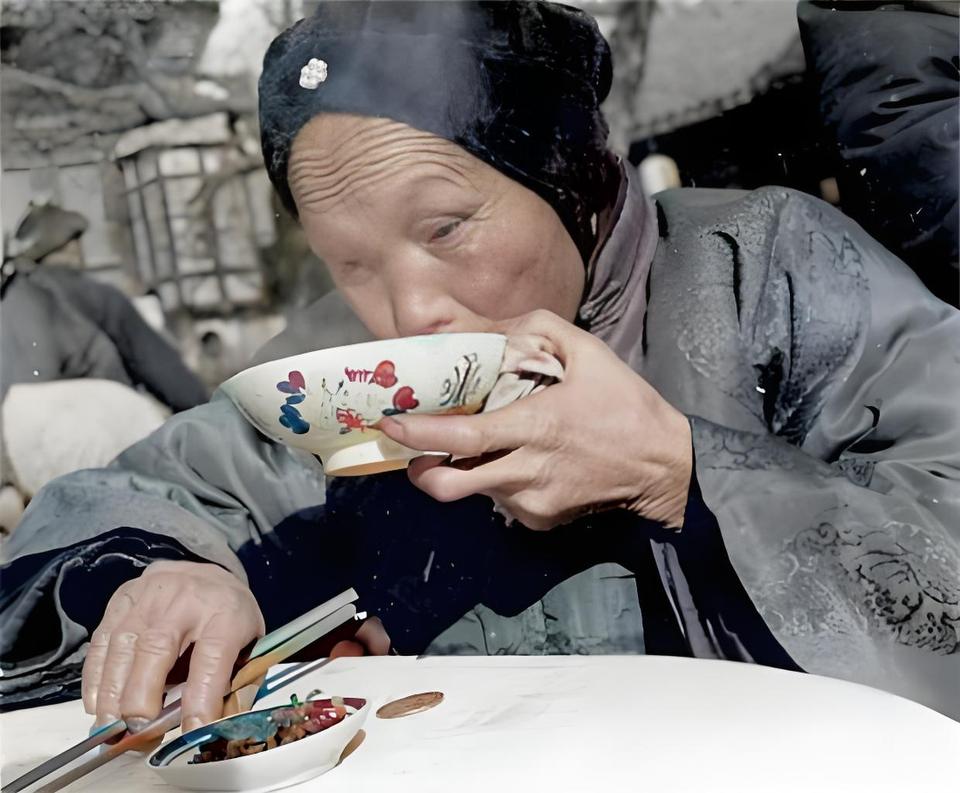 这张老照片里的场景，一看就是旧中国平民老百姓吃饭的日常。你瞧那老妇人，头上戴着旧