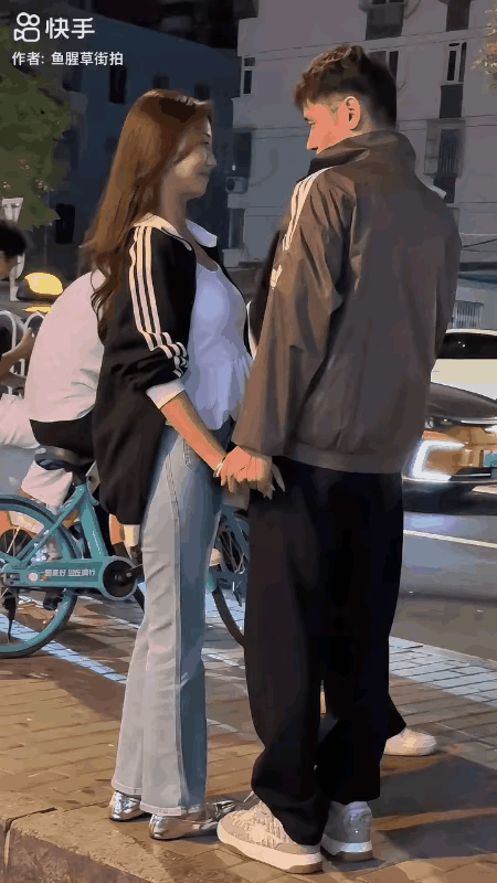 晚上街景。一对刚确定关系的小情侣，牵手站在夜幕下的街头，在男孩凝视下，女孩情不