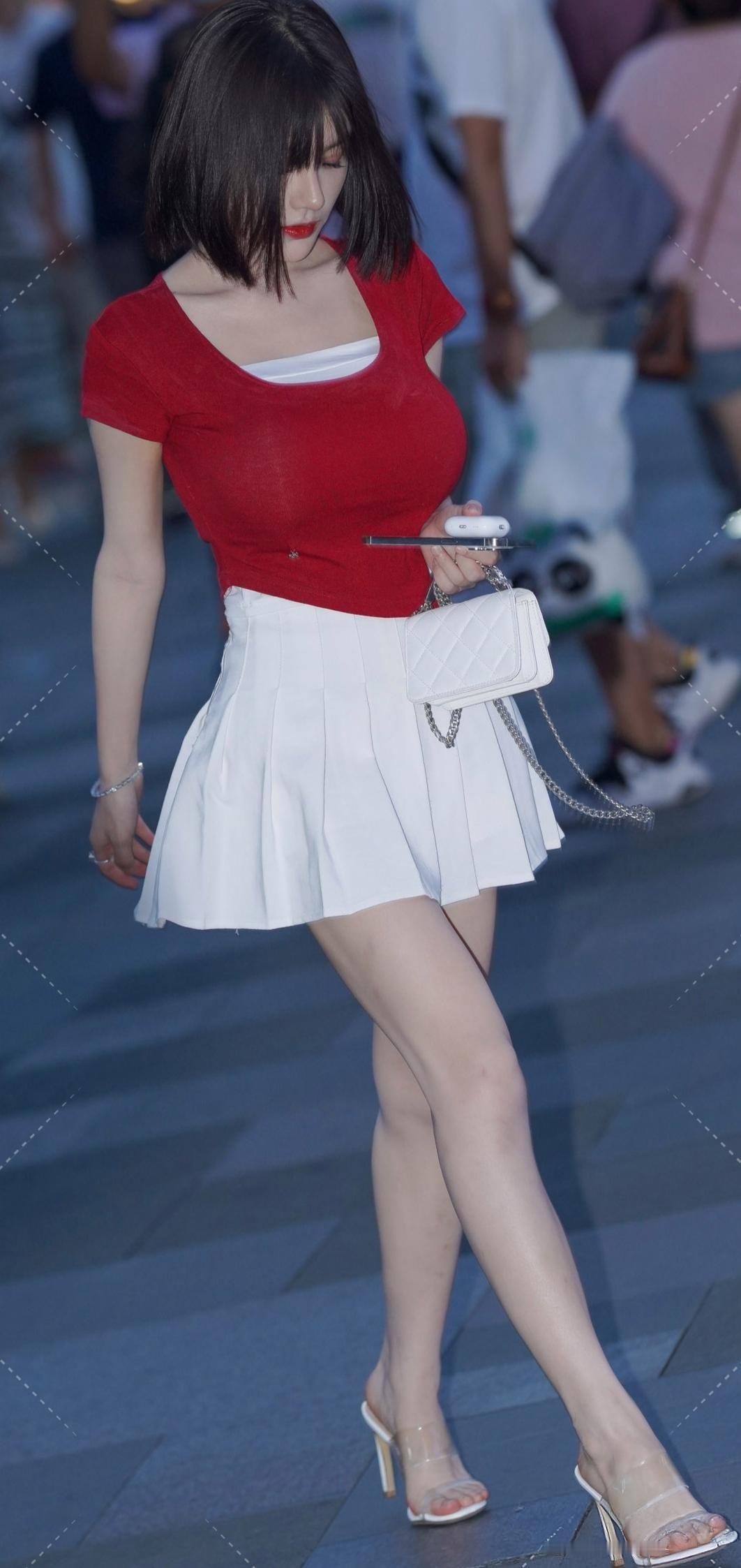 热烈的红上衣像盛夏的火焰，纯净的白百褶裙似初绽的百合，在暮色的街头交织出一抹亮眼